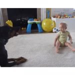 Doberman jugando con una bebe en la casa